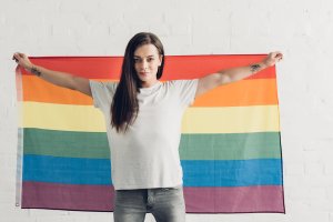 confident-transgender-man-holding-pride-flag-in-fr-XL9D3E8.jpg